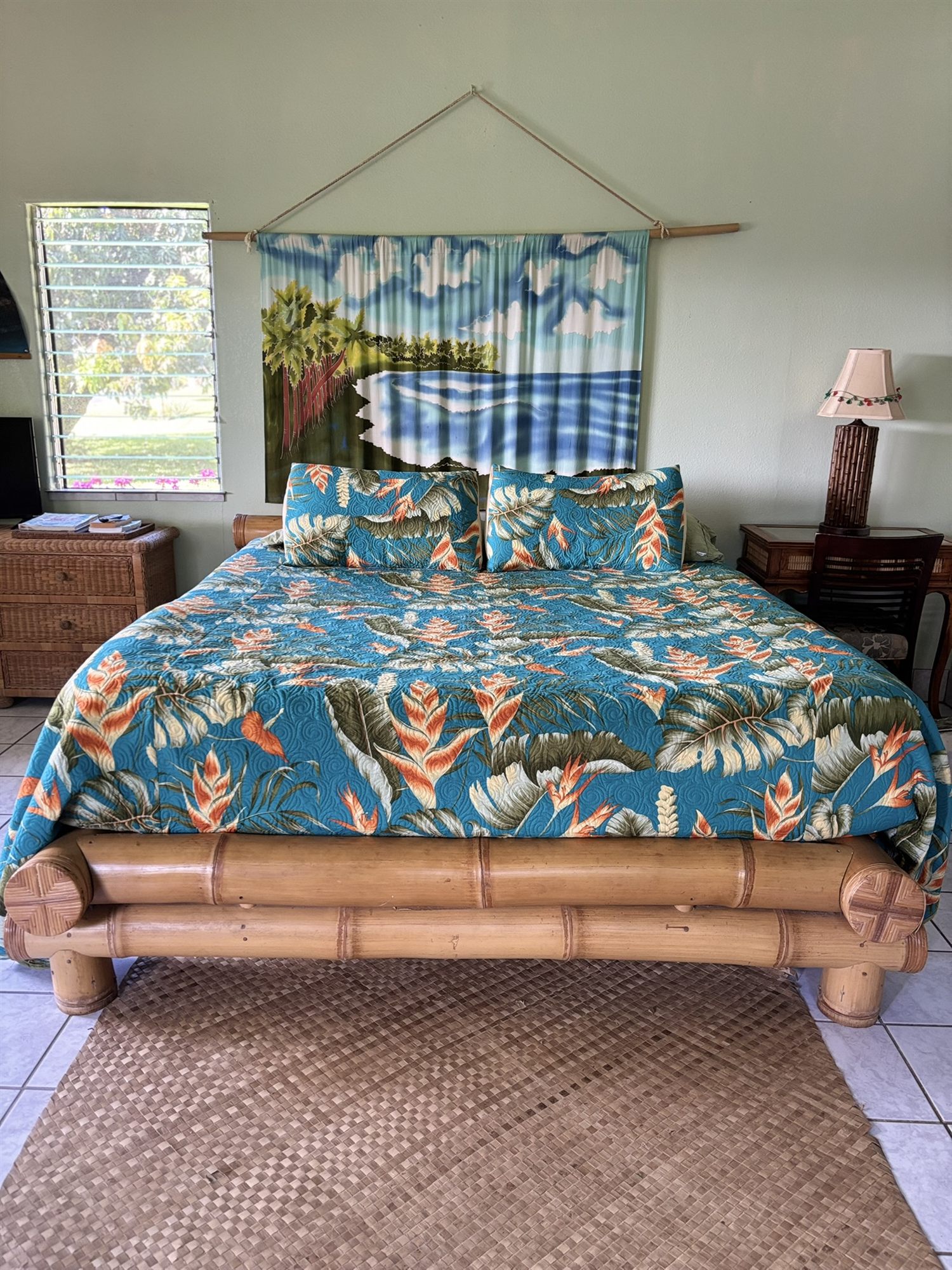 Bamboo king bed with a tropical-print quilt