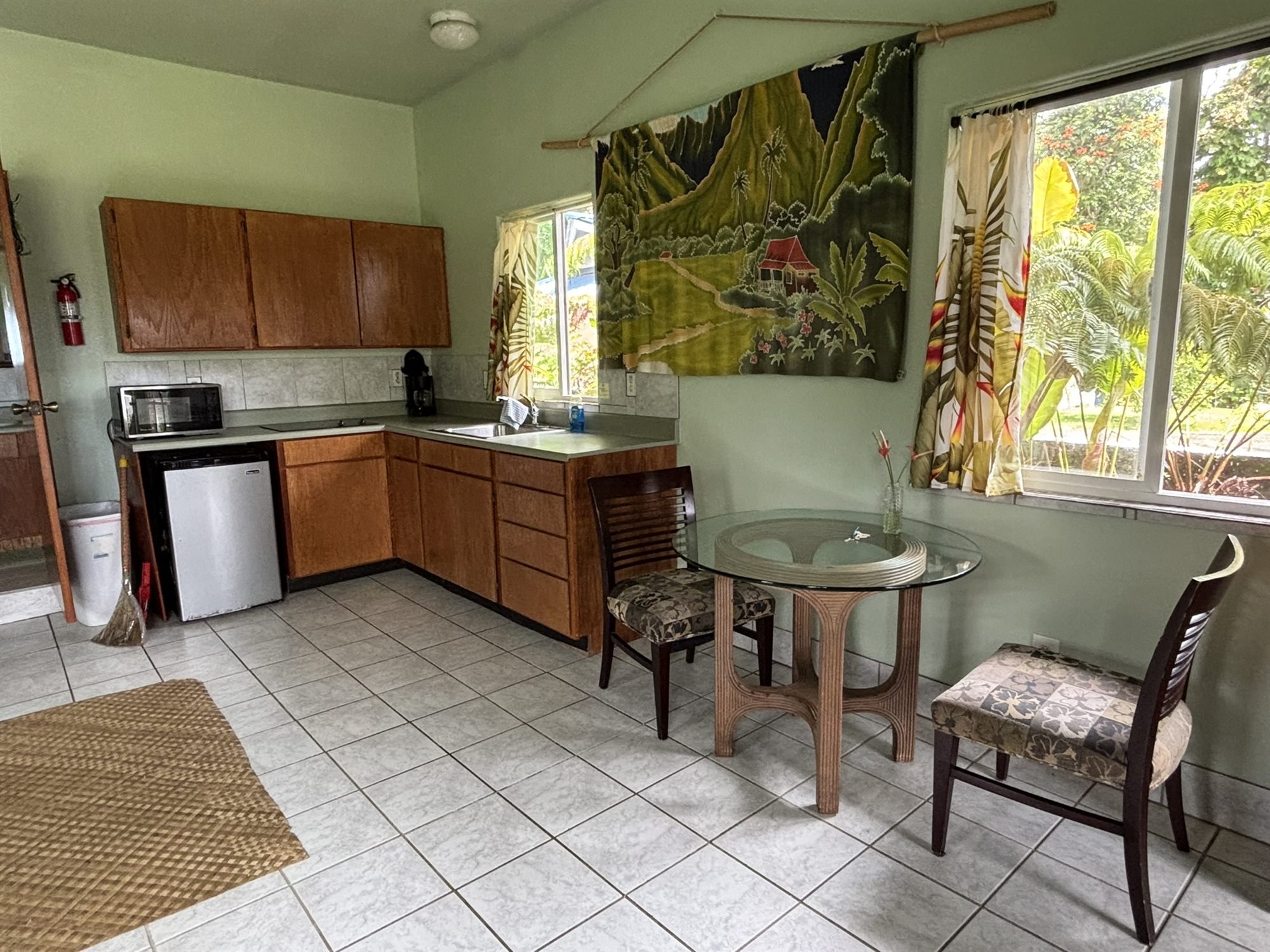 Kitchenette with wood cupboards and a glass breakfast table